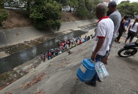 Caraqueños recogen agua en el río Guaire por el apagón